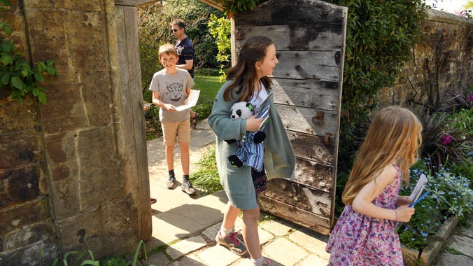 A group of children on a sunny day enjoying a trail around the garden
